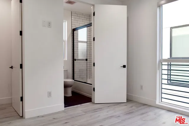 a view of a hallway with wooden floor and closet