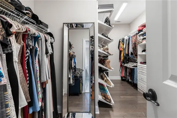 a view of walk in closet with clothes and shoes