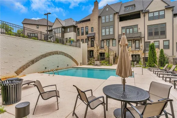 a front view of a house with porch and chairs