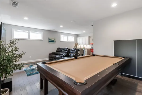 a room with furniture pool table and potted plants