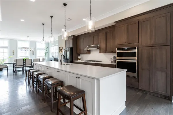 a kitchen with kitchen island white cabinets and stainless steel appliances