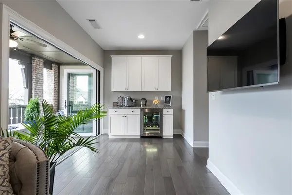 a kitchen with a refrigerator a stove top oven a potted plant and wooden floor