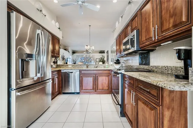 a kitchen with stainless steel appliances granite countertop a refrigerator a sink and wooden cabinets