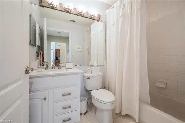 a bathroom with a sink a toilet and shower curtain