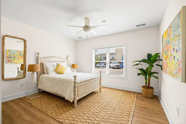 a room with a bed lamp and a potted plant