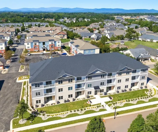 an aerial view of residential houses with outdoor space and parking