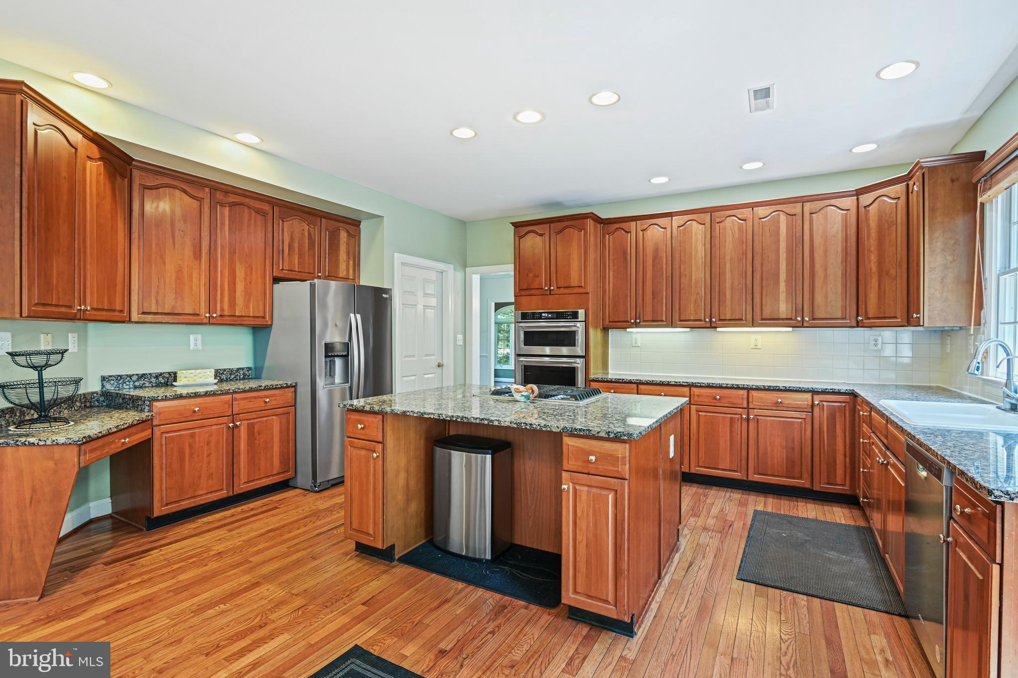 10509 Dunn Meadow Road Vienna, VA 22182 - Photo 17 of 81 a kitchen with stainless steel appliances granite countertop wooden cabinets a refrigerator a sink and dishwasher a oven with wooden floors