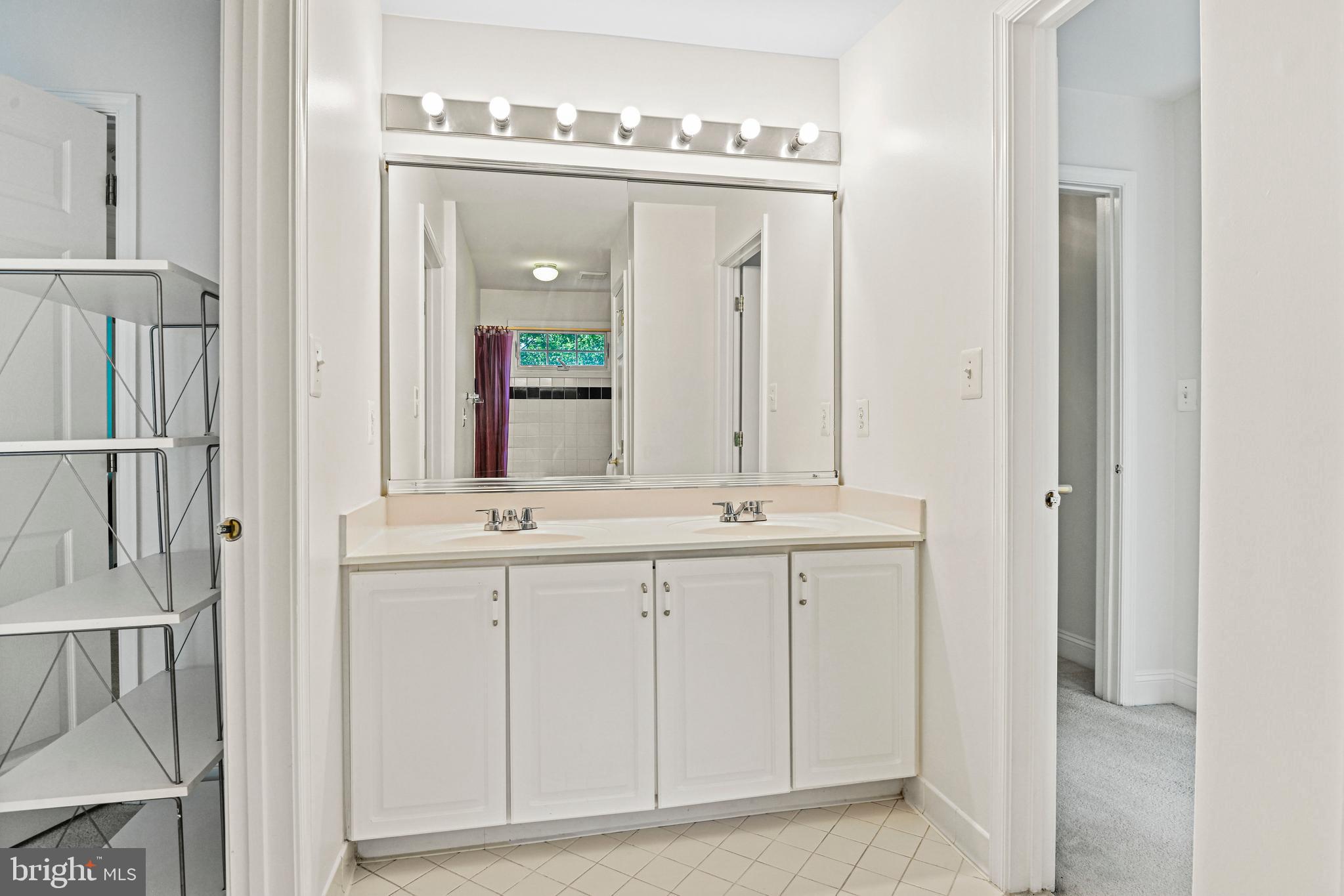 10509 Dunn Meadow Road Vienna, VA 22182 - Photo 35 of 81 a bathroom with a double vanity sink and a mirror