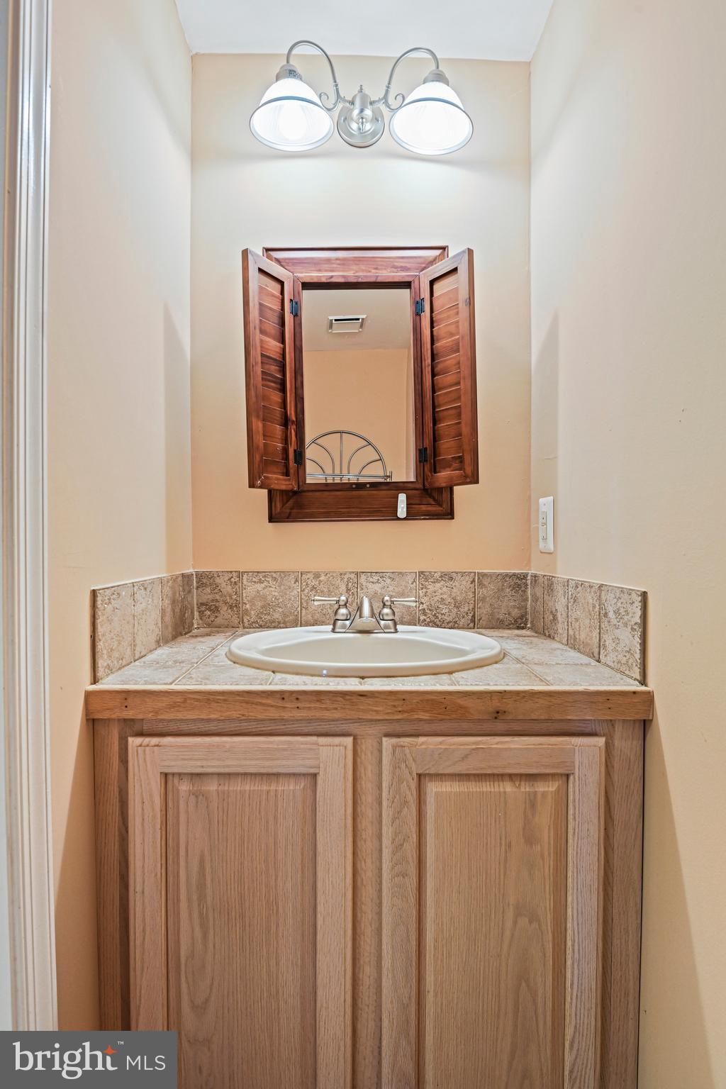 10509 Dunn Meadow Road Vienna, VA 22182 - Photo 51 of 81 a bathroom with a granite countertop sink and a mirror