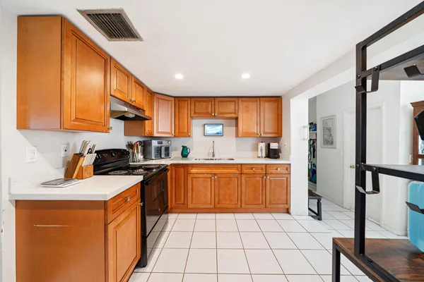 a kitchen with stainless steel appliances granite countertop a stove a sink dishwasher and a refrigerator