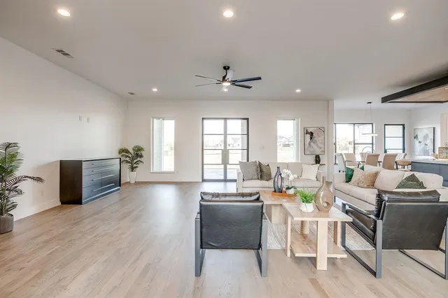 a living room with furniture a wooden floor and a chandelier