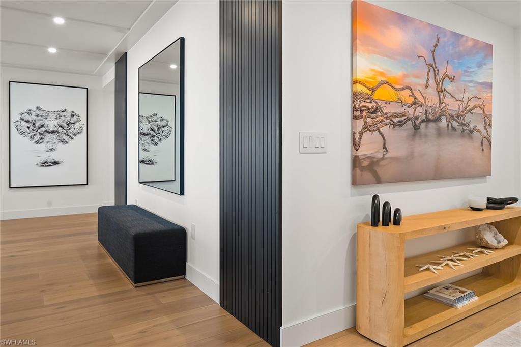 13935 Old Coast Road, Unit 2206 Naples, FL 34110 - Photo 23 of 50 Welcoming entry gallery featuring Dennis Goodman art and a hallway leading to the south guest suite