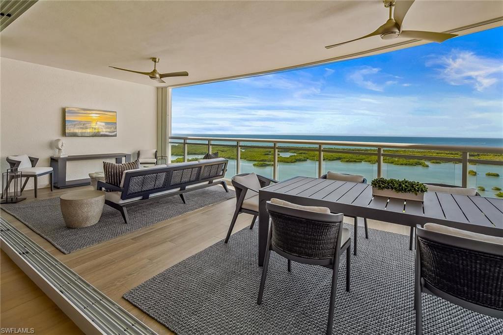 13935 Old Coast Road, Unit 2206 Naples, FL 34110 - Photo 27 of 50 An expansive 32-foot sunset terrace seamlessly connected by pocketing impact doors, offering inviting outdoor living and dining spaces.
