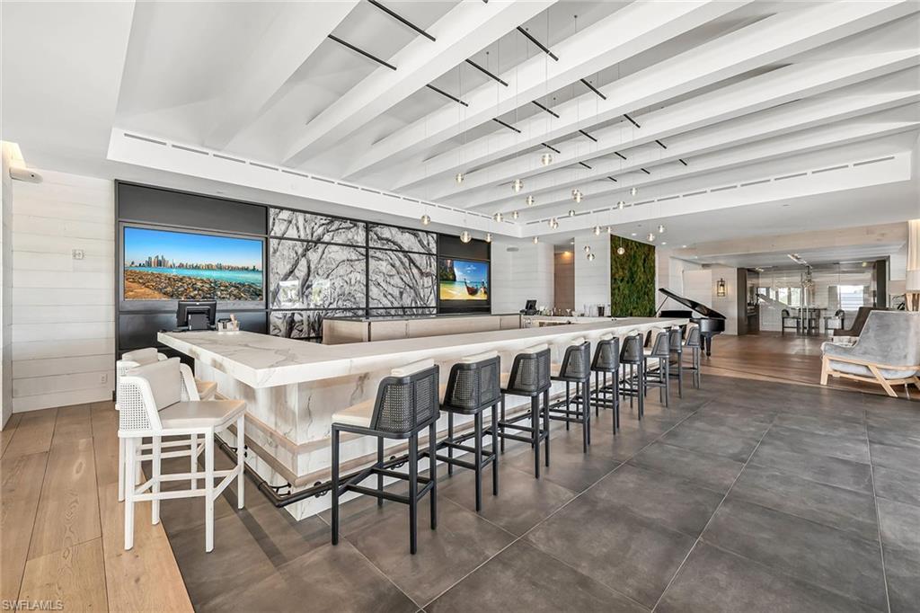 13935 Old Coast Road, Unit 2206 Naples, FL 34110 - Photo 36 of 50 Elegant bar and gathering space, featuring a grand piano and an inviting setting for live music, social events, and memorable gatherings