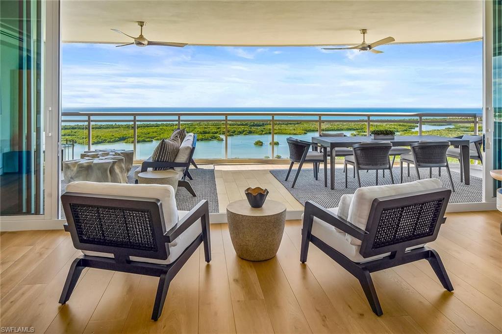 13935 Old Coast Road, Unit 2206 Naples, FL 34110 - Photo 6 of 50 Enjoy effortless indoor–outdoor living, with the furnished great room opening to a generous glass-railed terrace that expands the living area.