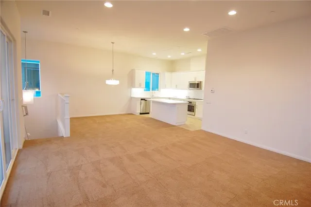 a view of a kitchen with a sink and dishwasher a refrigerator with white walls
