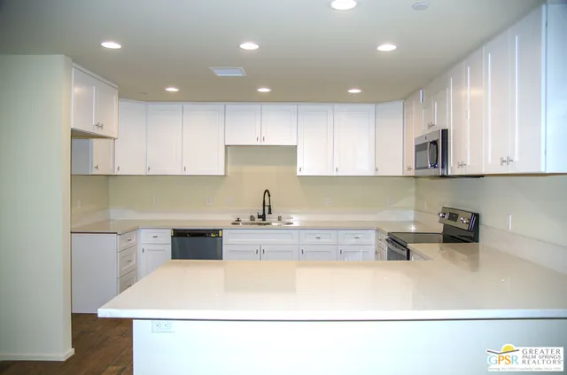 a kitchen with a sink a stove and cabinets