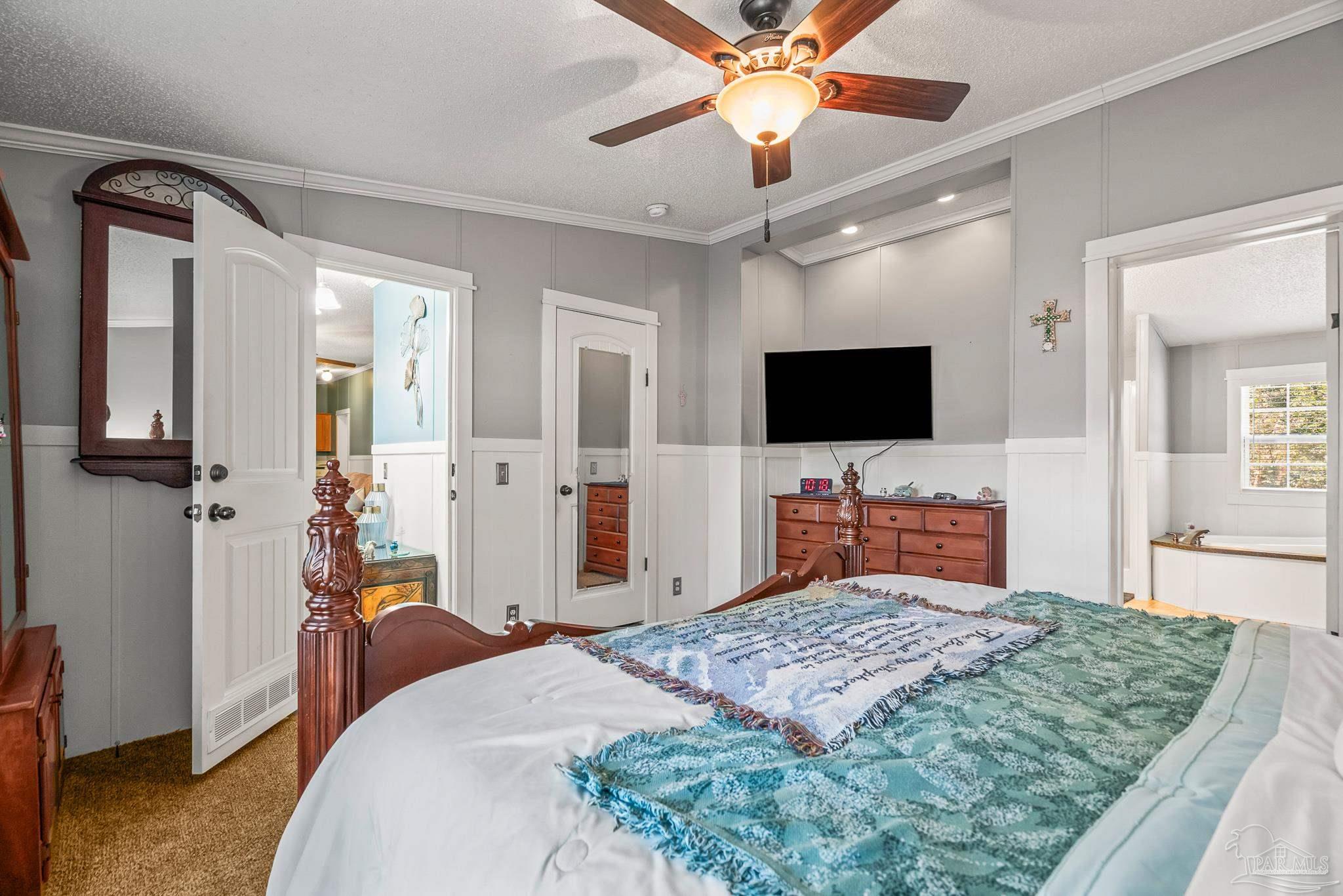 5105 April Lane Pace, FL 32571 - Photo 27 of 57 a bedroom with a bed and a flat screen tv