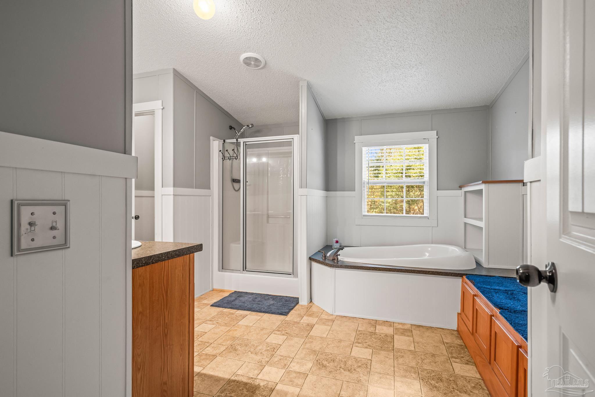 5105 April Lane Pace, FL 32571 - Photo 29 of 57 a spacious bathroom with a tub sink shower and a mirror
