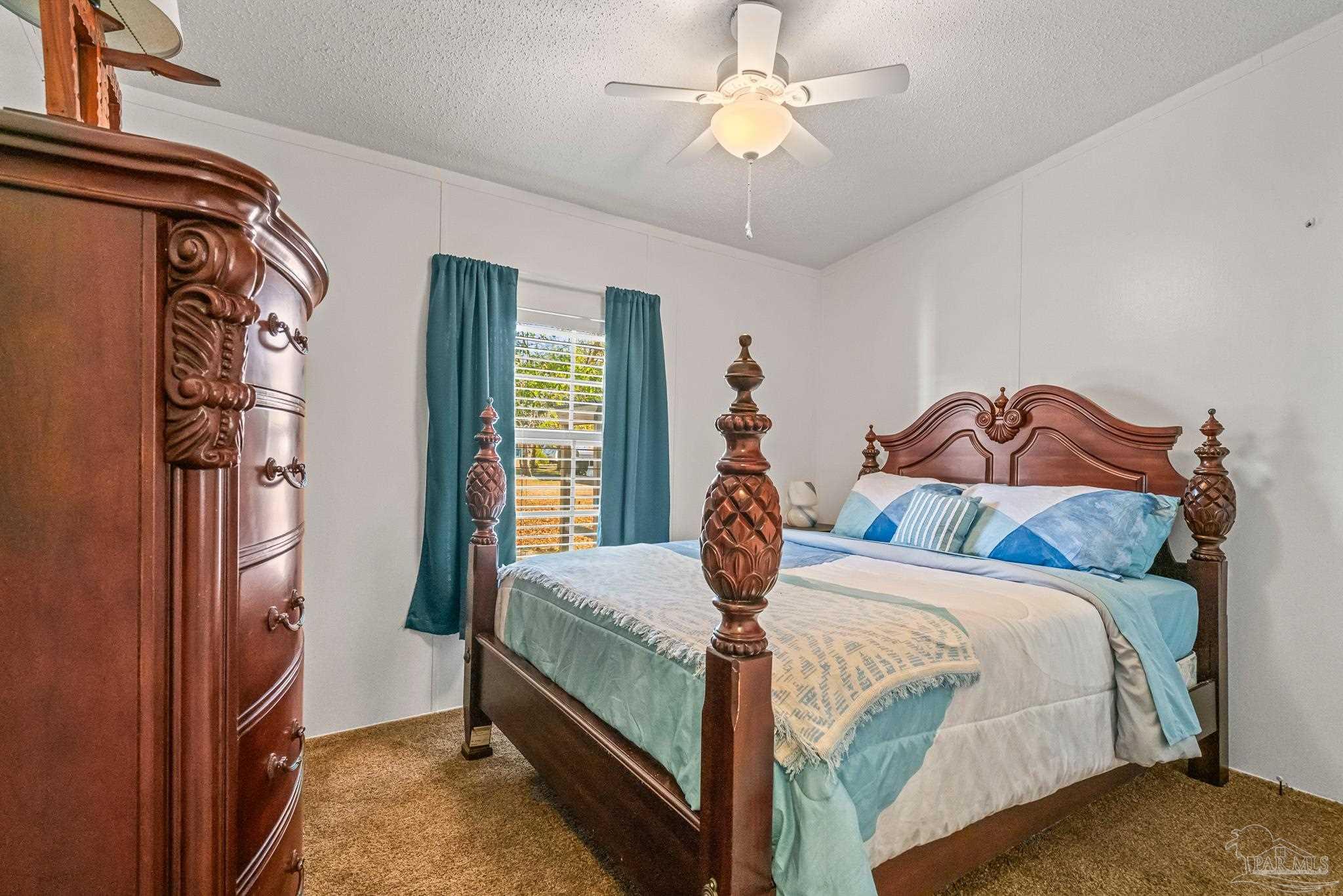 5105 April Lane Pace, FL 32571 - Photo 37 of 57 a bedroom with a bed and a chandelier