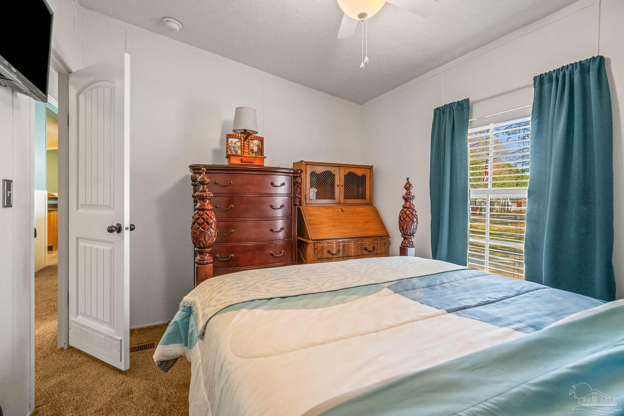 5105 April Lane Pace, FL 32571 - Photo 38 of 57 a bedroom with a bed and a chandelier
