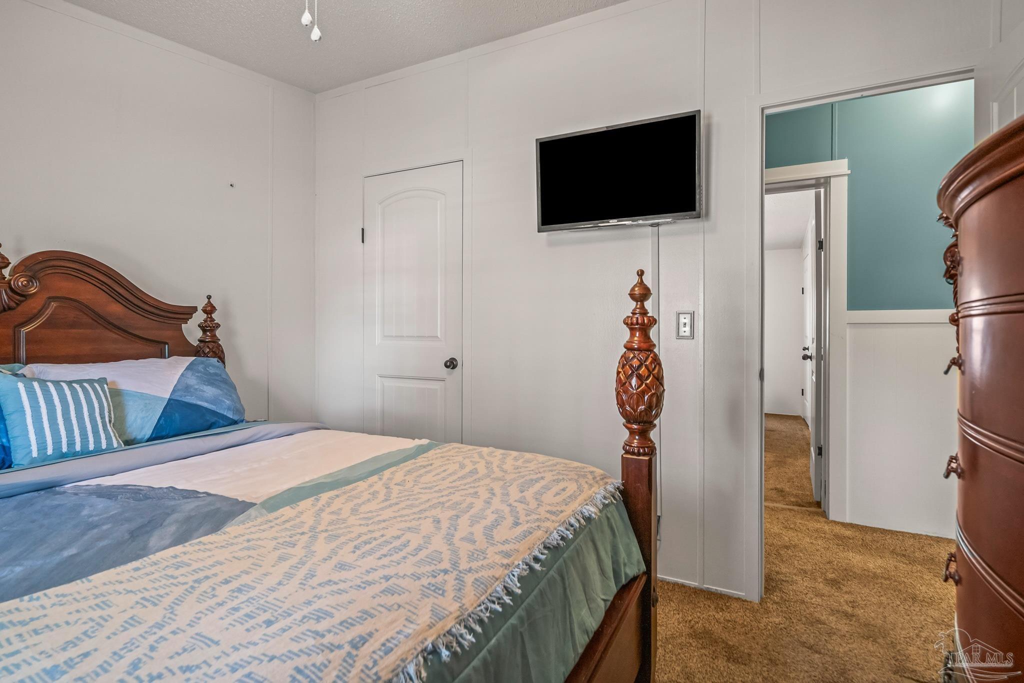 5105 April Lane Pace, FL 32571 - Photo 39 of 57 a bedroom with a bed and a flat screen tv