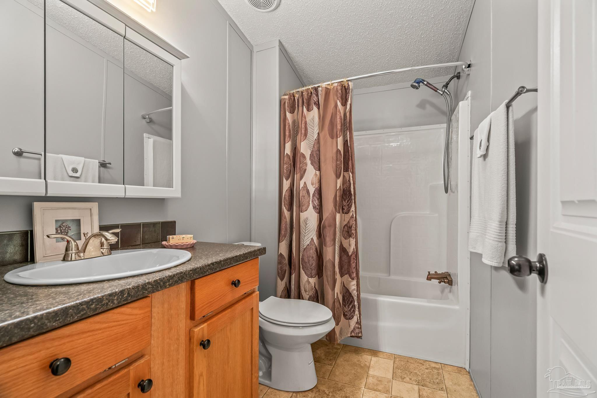 5105 April Lane Pace, FL 32571 - Photo 44 of 57 a bathroom with a granite countertop sink toilet and shower