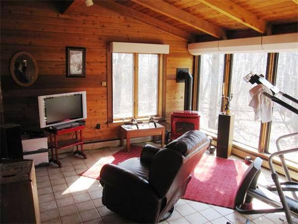 280 Mountain Road Gill, MA 01354 - Photo 6 of 26 a living room with furniture a flat screen tv and a floor to ceiling window
