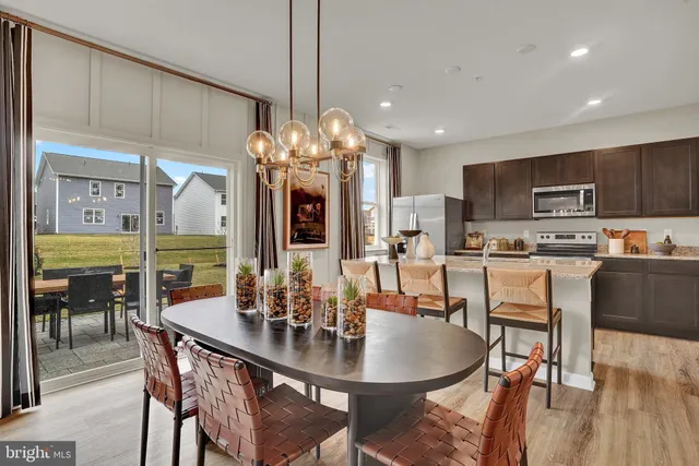 a dining room filled chandelier and kitchen view