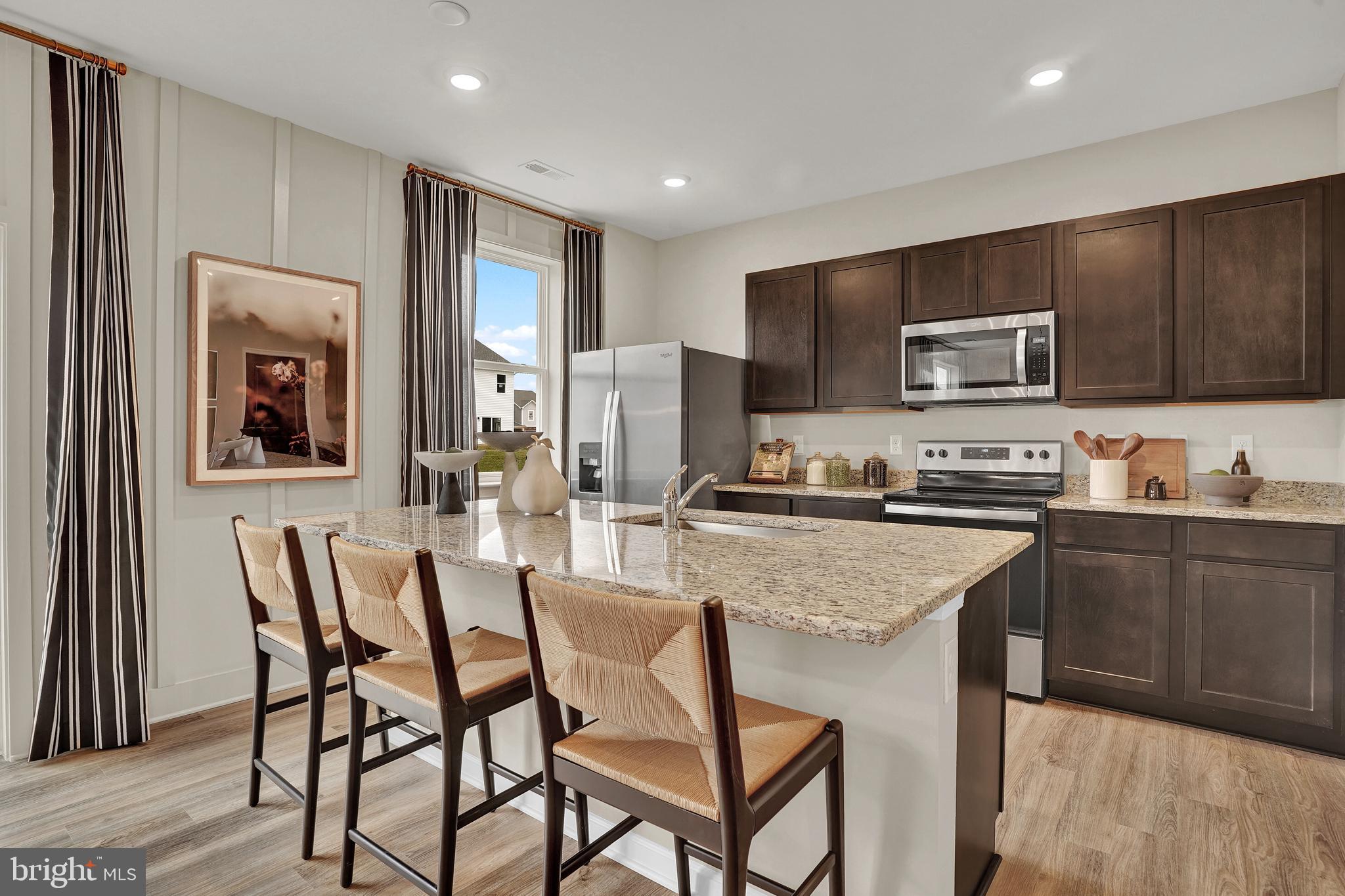 301 Eclipse Street Ranson, WV 25438 - Photo 5 of 26 a kitchen with stainless steel appliances granite countertop a stove a sink dishwasher a refrigerator and a oven with wooden floor