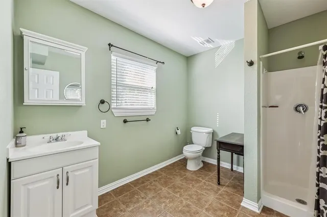 a bathroom with a sink a toilet and a window