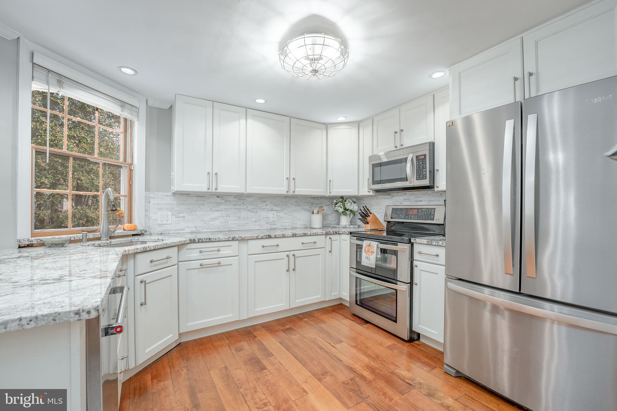 111 Harrogate Road Wynnewood, PA 19096 - Photo 17 of 60 a kitchen with granite countertop stainless steel appliances a refrigerator cabinets and wooden floor