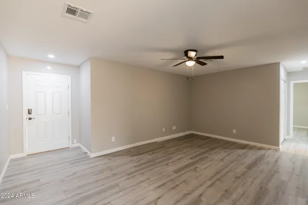 a view of an empty room with wooden floor