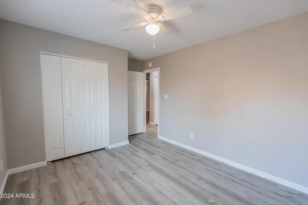 a view of an empty room and chandelier fan