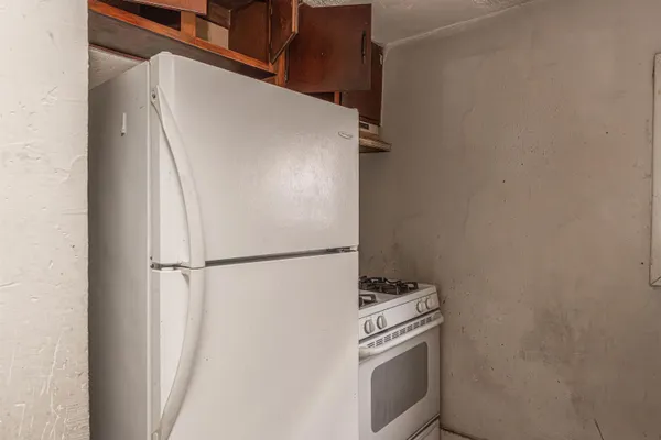 a white refrigerator freezer and a stove sitting inside of a kitchen
