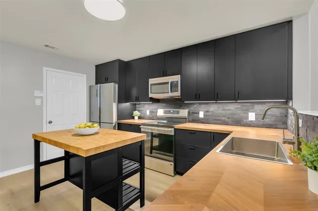 a kitchen with a sink cabinets and stainless steel appliances