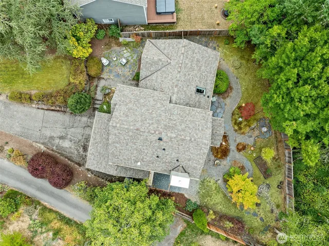 an aerial view of a house with a garden and lake view