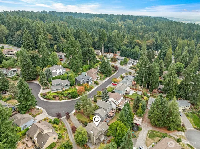 an aerial view of residential houses with outdoor space and trees