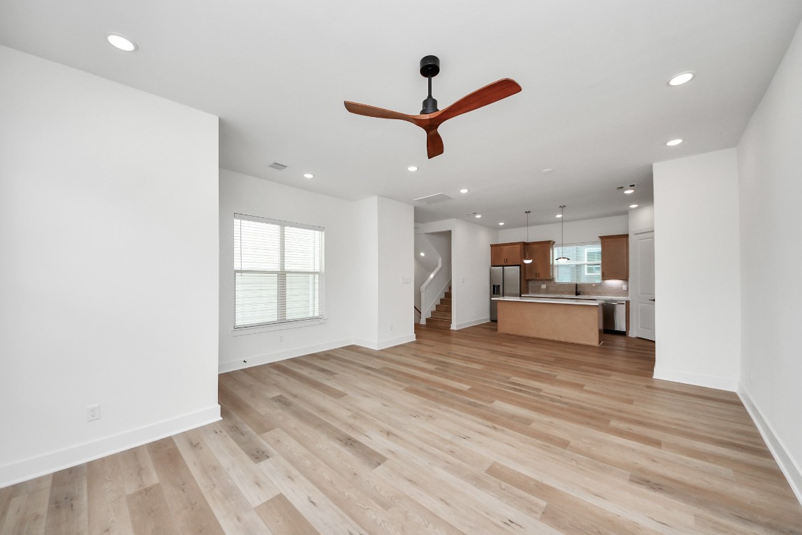 3313 Daphne Street Houston, TX 77021 - Photo 12 of 34 a view of a livingroom with kitchen island stainless steel appliances wooden floor and window