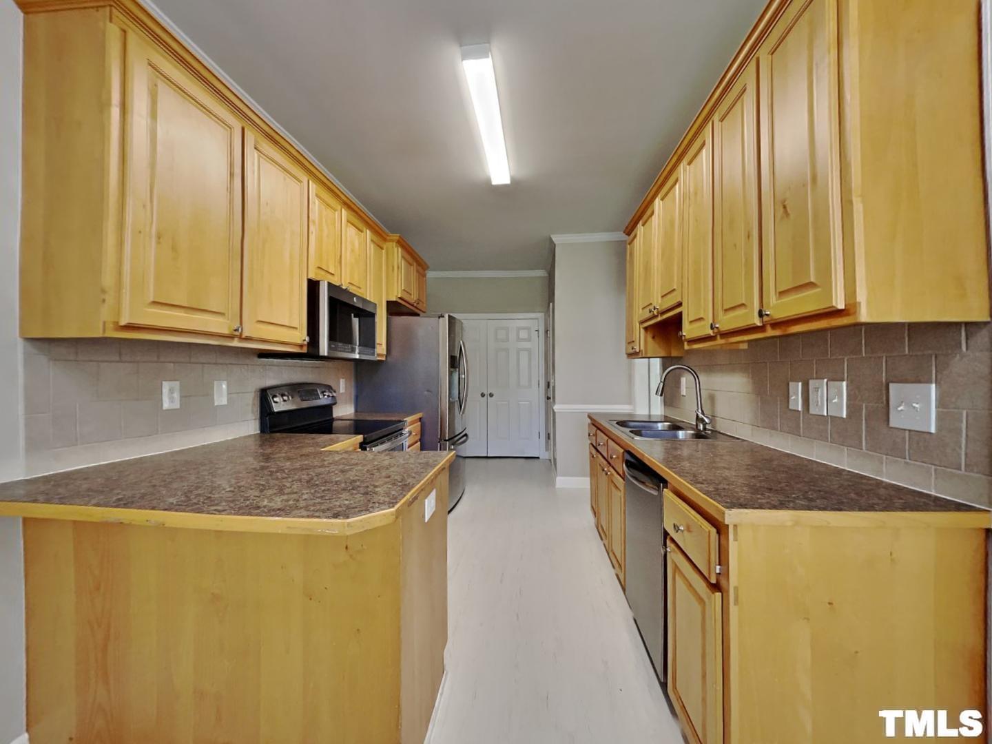 225 Bear Oak Drive Smithfield, NC 27577 - Photo 4 of 17 a kitchen with stainless steel appliances granite countertop a sink a stove and a refrigerator