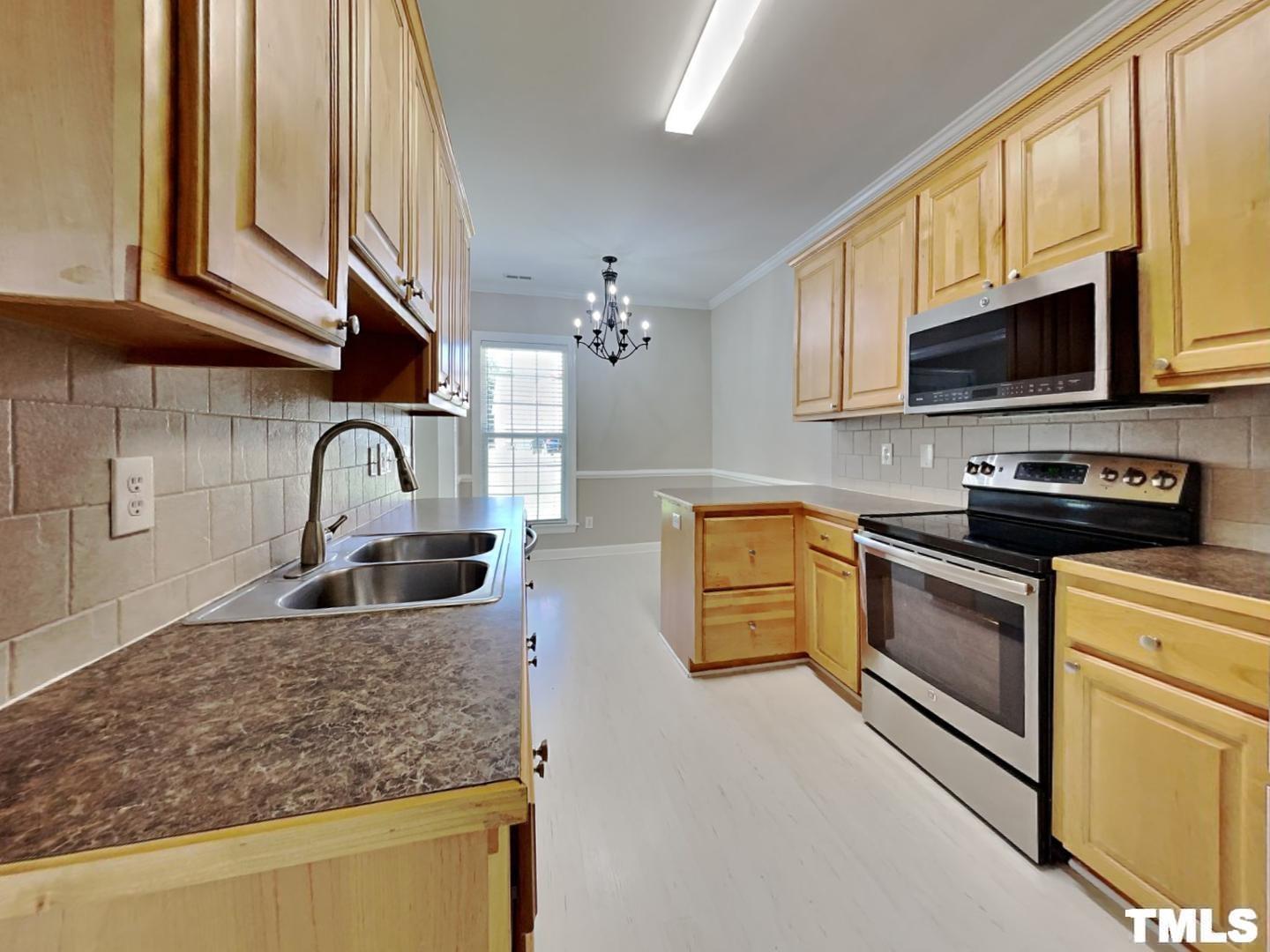 225 Bear Oak Drive Smithfield, NC 27577 - Photo 5 of 17 a kitchen with stainless steel appliances granite countertop a sink a stove and microwave