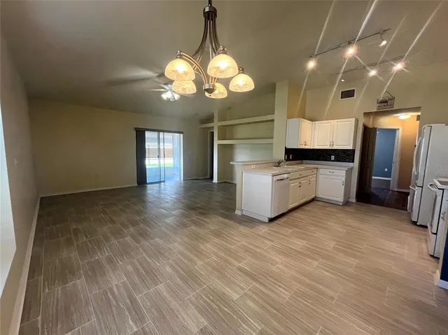 a view of a kitchen with a sink and dishwasher a oven with wooden floor