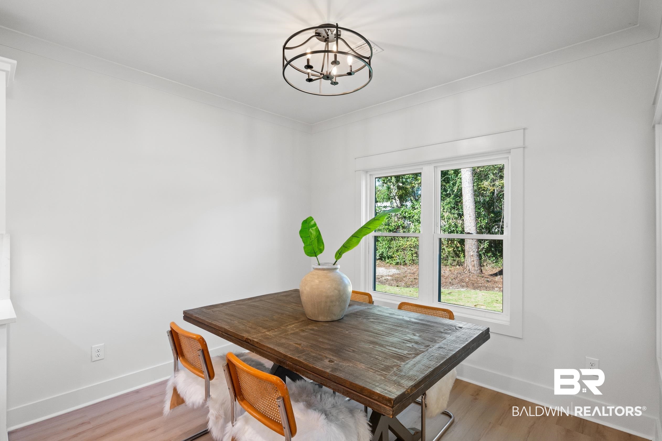 28889 Canal Road Orange Beach, AL 36561 - Photo 11 of 55 Dining room featuring light wood-type flooring, ornamental molding, and a chandelier
