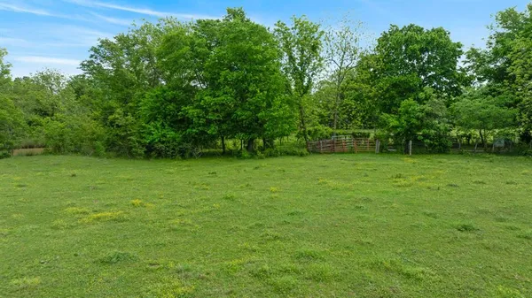 a view of a field with trees in the background