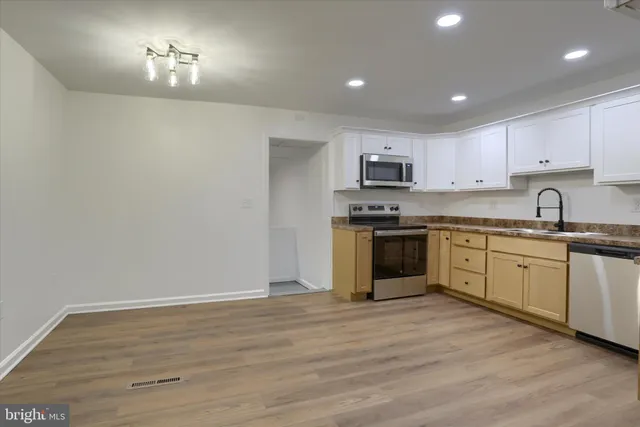 a kitchen with granite countertop white cabinets stainless steel appliances and sink