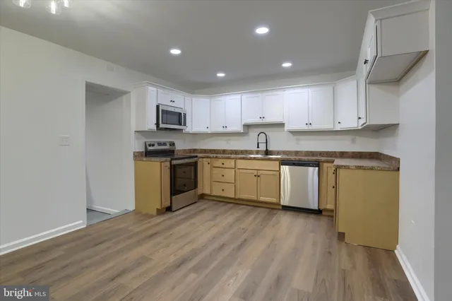 a kitchen with granite countertop white cabinets white stainless steel appliances with a sink and dishwasher