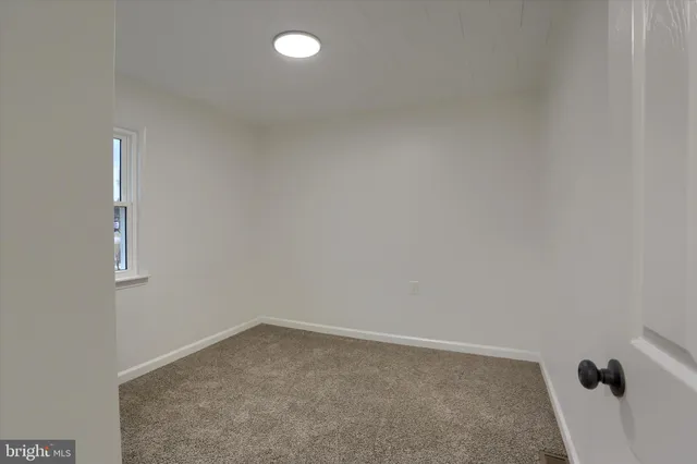 a view of an empty room with windows and closet