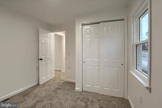 an empty room with windows and closet