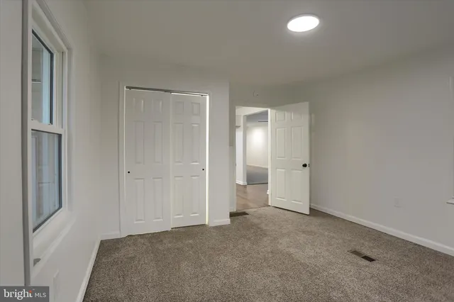 a view of a room with wooden floor and a window