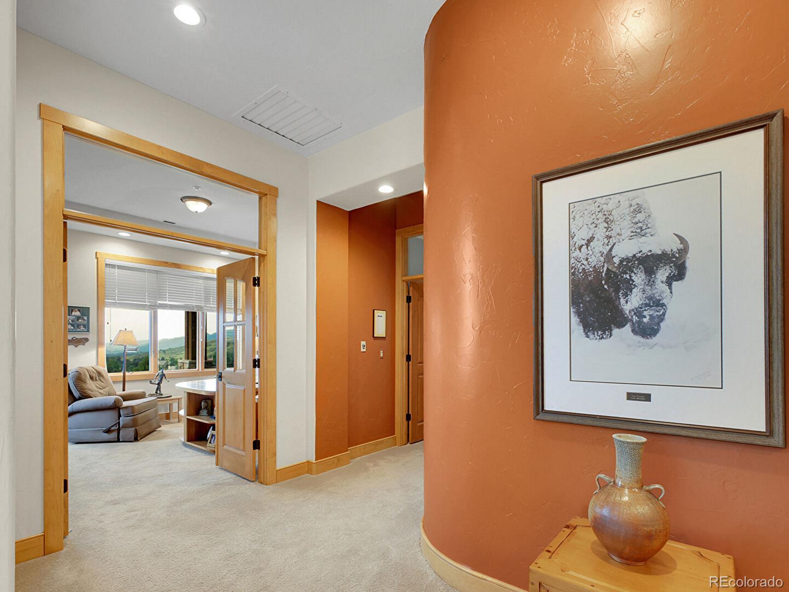 16285 Sandstone Drive Morrison, CO 80465 - Photo 18 of 47 a view of a hallway with a big room and mirror